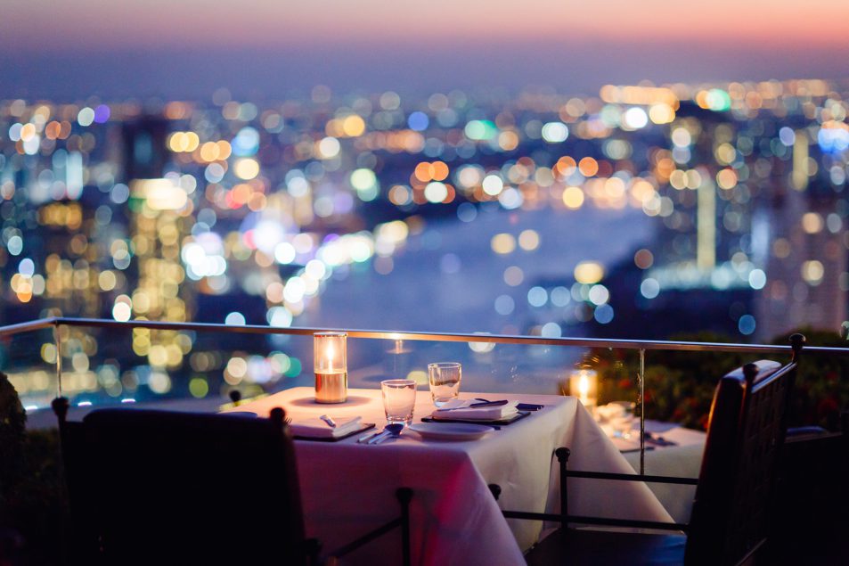 set dinner table with candles by river view balcony