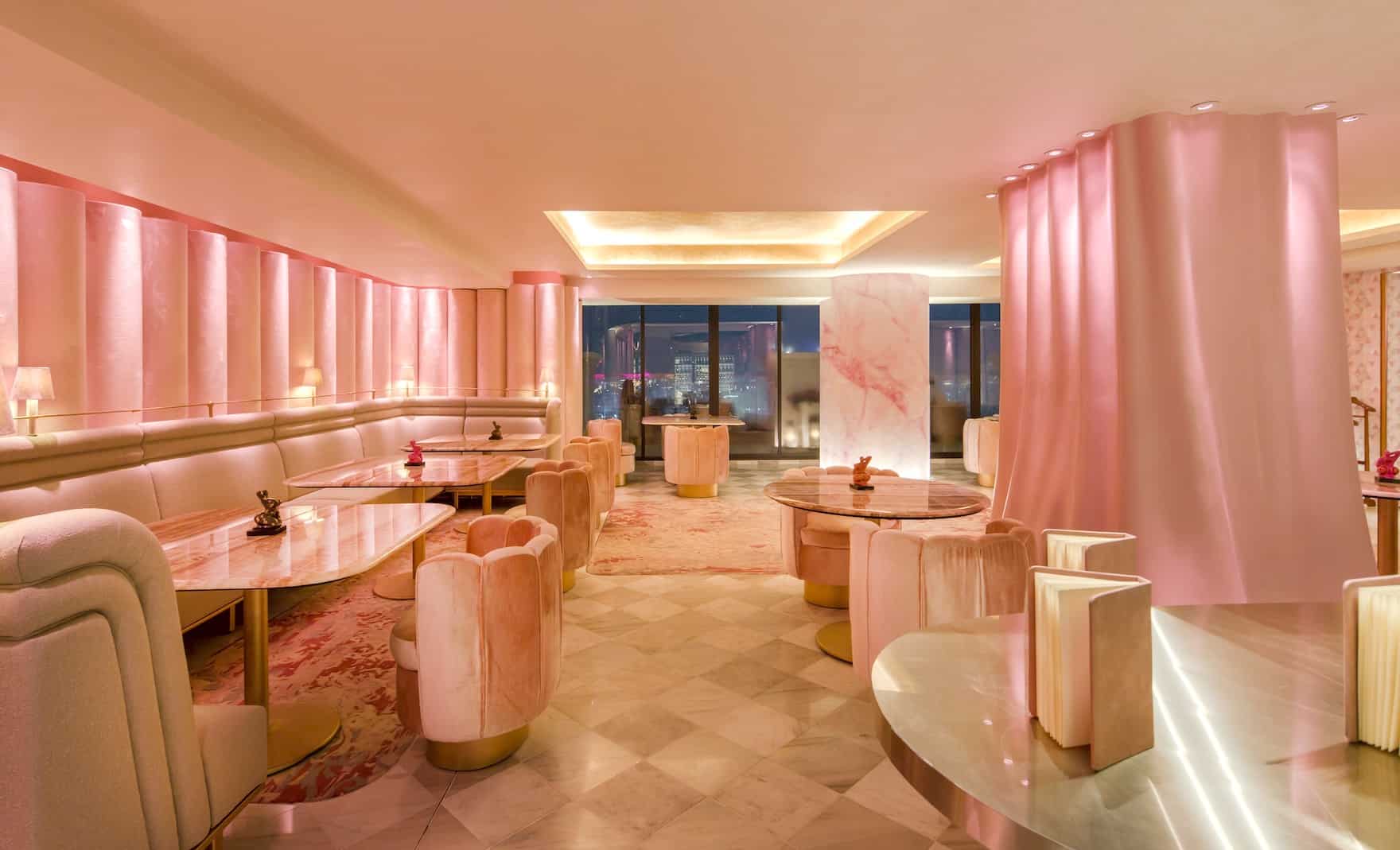 4 restaurant tables pink furniture and walls row of booths on left side